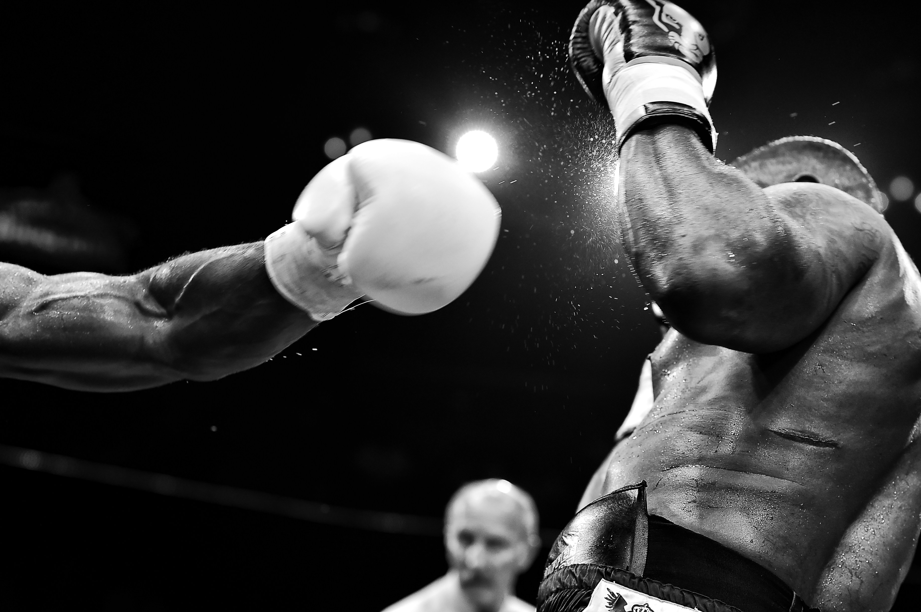 Black-and-White Action Shot of Boxer Being Punched with Referee in Background for Philadelphia Boxing Event 2025